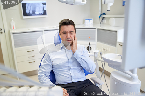 Image of man having toothache and sitting on dental chair