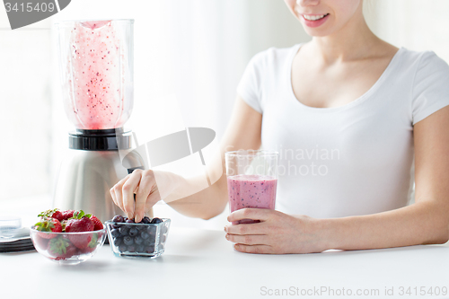 Image of close up of woman with blender and milk shake