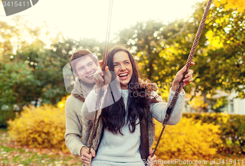 Image of smiling couple hugging in autumn park