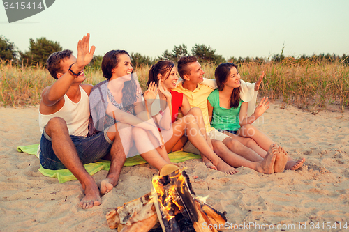 Image of smiling friends in sunglasses on summer beach