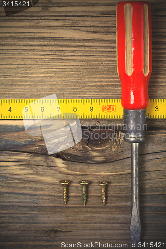 Image of old screwdriver, screws and measuring lenght