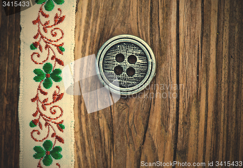 Image of vintage band with embroidered ornaments and old button