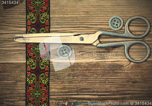 Image of antique embroidered tape, vintage buttons and a tailor scissors