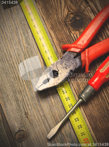 Image of vintage pliers, old screwdriver and measuring tape