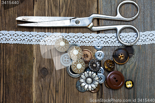 Image of antique buttons, lace and a tailor scissors