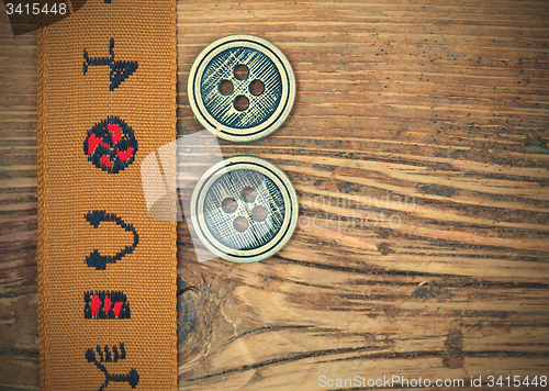 Image of vintage band with embroidered ornaments and old button