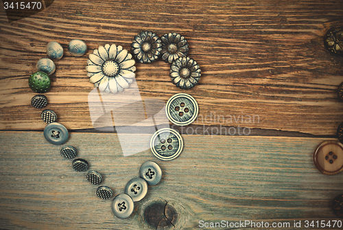 Image of antique buttons heart on old textured boards
