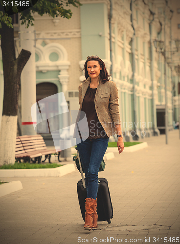 Image of pretty adult businesswoman with a suitcase