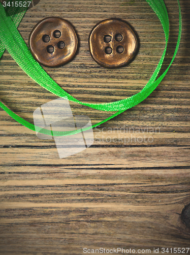 Image of still life with old green tape and two vintage buttons