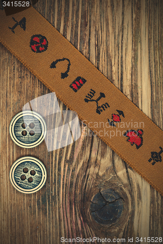 Image of vintage band with embroidered ornaments and old button