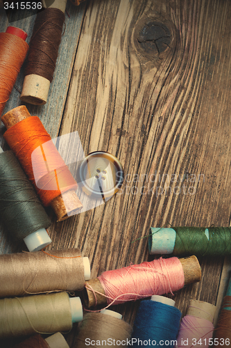 Image of Vintage spools with multi colored threads and old button