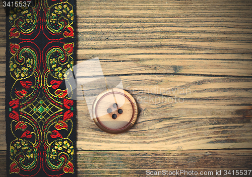 Image of old band with embroidered ornaments and vintage button