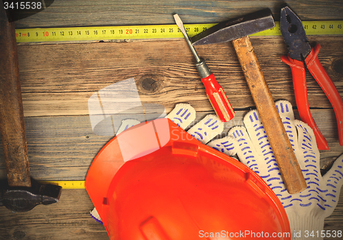 Image of Vintage hammer, pliers, screwdriver, tape measure, a bright helm