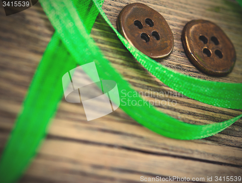 Image of still life with old green tape and two vintage buttons