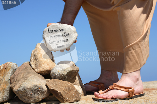 Image of Man holding rock with bible verse John 8:7