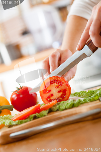 Image of Woman\'s hands cutting tomato