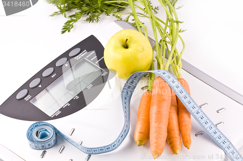 Image of carrots, apple and measuring objects