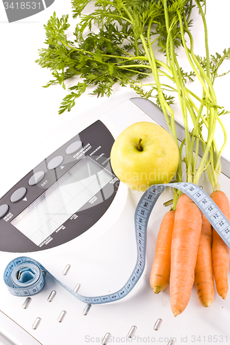 Image of carrots, apple and measuring objects