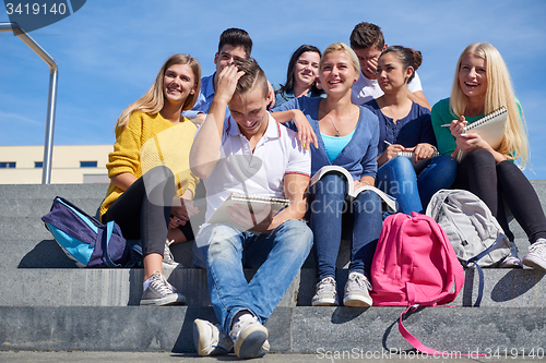 Image of students outside sitting on steps