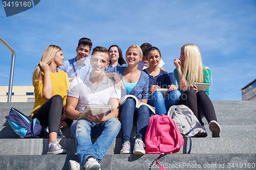 Image of students outside sitting on steps