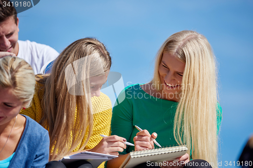 Image of students outside sitting on steps