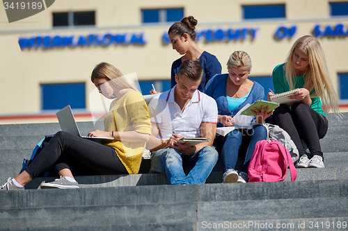 Image of students outside sitting on steps