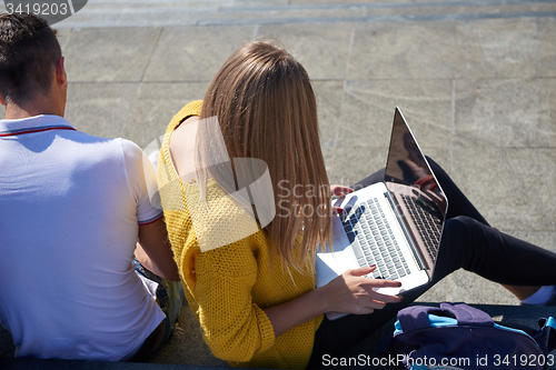 Image of students outside sitting on steps