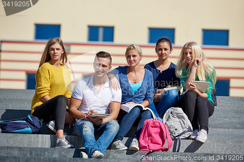 Image of students outside sitting on steps