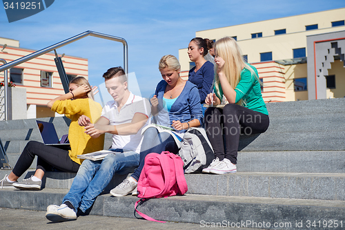 Image of students outside sitting on steps