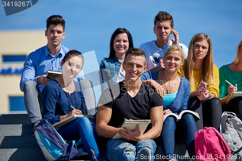 Image of students outside sitting on steps