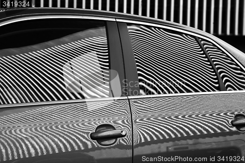 Image of Car and stripes, car parked in front of a building with striped 