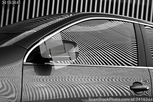 Image of Car and stripes, car parked in front of a building with striped 