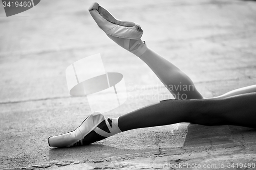 Image of Ballerina feet close-up on a background of textured concrete wal