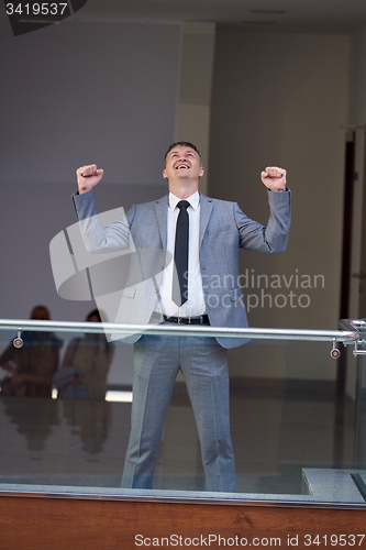 Image of happy business man raise hands from joy