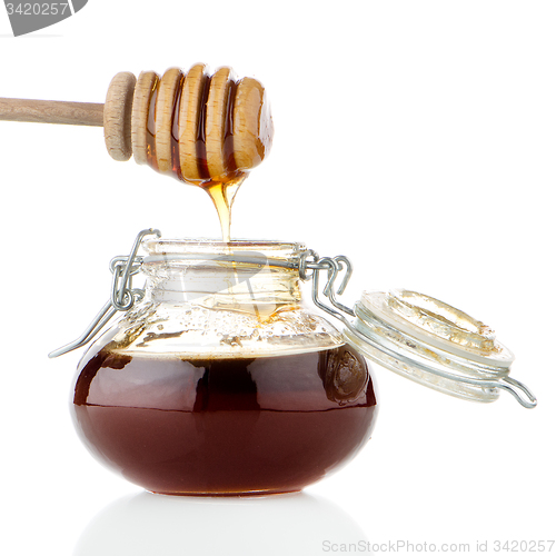 Image of Jar of honey with wooden drizzler