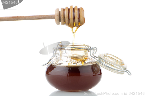 Image of Jar of honey with wooden drizzler