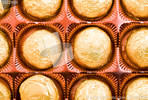 Image of packed in foil chocolates, lying in a box