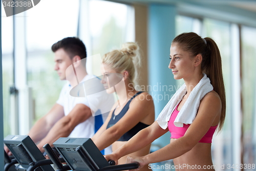 Image of friends  exercising on a treadmill at the bright modern gym