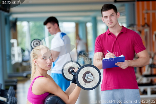 Image of young sporty woman with trainer exercise weights lifting