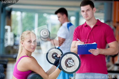 Image of young sporty woman with trainer exercise weights lifting
