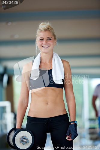 Image of lifting some weights and working on her biceps in a gym