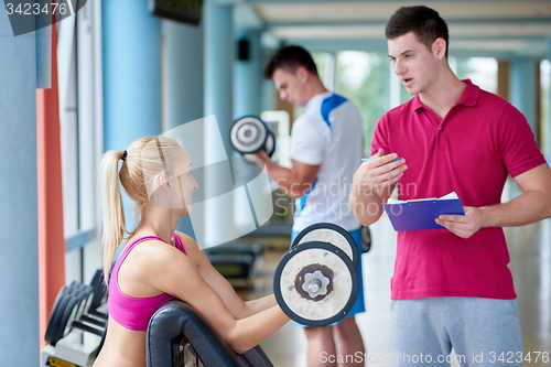 Image of young sporty woman with trainer exercise weights lifting