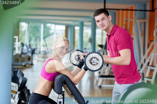 Image of young sporty woman with trainer exercise weights lifting