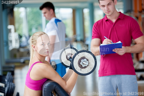 Image of young sporty woman with trainer exercise weights lifting