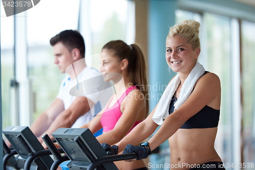 Image of friends  exercising on a treadmill at the bright modern gym