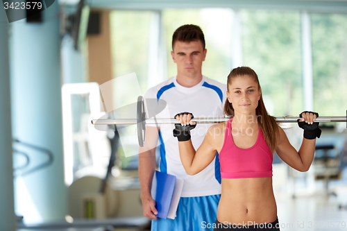Image of young sporty woman with trainer exercise weights lifting