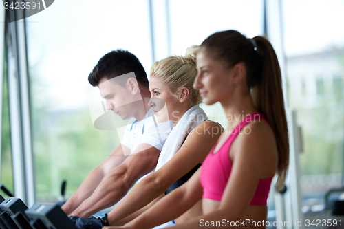 Image of friends  exercising on a treadmill at the bright modern gym