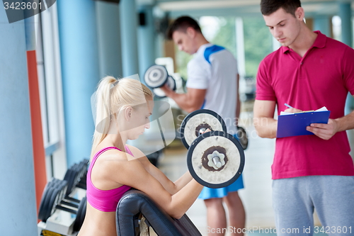 Image of young sporty woman with trainer exercise weights lifting