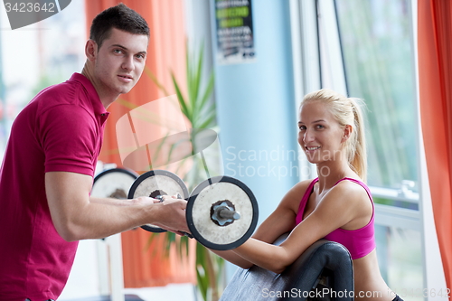 Image of young sporty woman with trainer exercise weights lifting