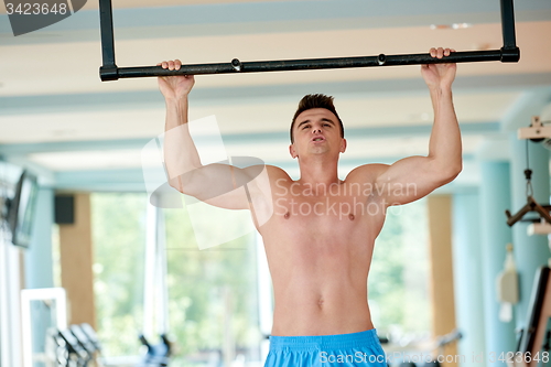 Image of handsome young mand working out in gym